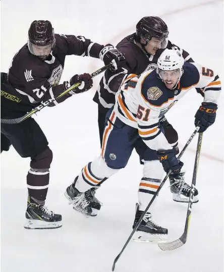  ?? GREG SOUTHAM ?? Edmonton Oilers rookie Dave Gust squeezes between NAIT-MacEwan All-Stars Brayden Harris and Nolan Yaremchuk in the first period Tuesday. The Oilers out-shot NAIT-MacEwan 68-16 in their 9-1 win.