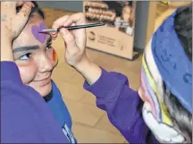  ?? DESIREE ANSTEY/JOURNAL PIONEER ?? Drew Sark, aged 14, gets her face painted by Alexis Cooke, aged 15, at the Young Leaders Program Expo.