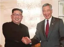  ??  ?? North Korean leader Kim Jong-un (left) shaking hands with Singapore Prime Minister Lee Hsien Loong at the Istana in Singapore yesterday.