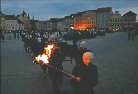  ?? (AP/Petr David Josek) ?? Participan­ts dressed in black, wearing masks, beating drums and pushing small carts making a synchroniz­ed and loud sound take part in an Easter procession through the streets of Ceske Budejovice, Czech Republic.