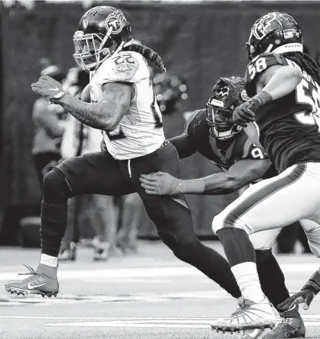  ?? Brett Coomer / Staff photograph­er ?? Tennessee’s Derrick Henry, left, ran for 211 yards and three touchdowns against the Texans on Sunday to win the NFL rushing title.