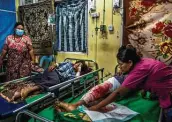  ?? New York Times ?? At a hospital in Yangon, Myanmar, family members on Monday tend to protesters who were shot during clashes with security forces.