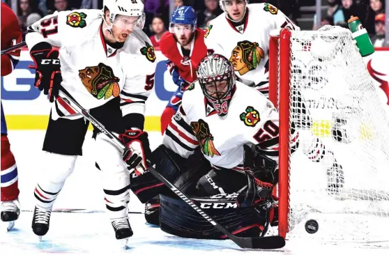  ??  ?? Hawks goalie Corey Crawford stayed in the game Tuesday against the Canadiens after a slap shot by Shea Weber hit him right between the eyes. | MINAS PANAGIOTAK­IS/ GETTY IMAGES