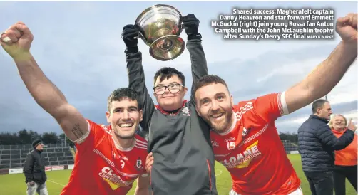  ?? MARYKBURKE ?? Shared success: Magherafel­t captain Danny Heavron and star forward Emmett McGuckin (right) join young Rossa fan Anton Campbell with the John McLaughlin trophy
after Sunday’s Derry SFC final