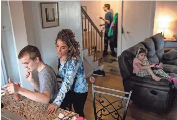  ?? ANTRANIK TAVITIAN/DFP ?? Danielle Vernon-Carleton watches her stepson Jackson, 16, do a virtual physical therapy class as daughter Bella, right, gets ready and stepson Andrew, top, paces.