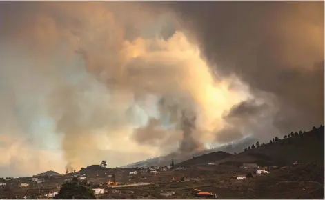  ?? — AFP photo ?? Mount Cumbre Vieja erupts spewing a column of smoke and ash as seen from Los Llanos de Aridane on the Canary island of La Palma.