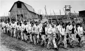  ?? ?? Prisoners at Parchman Farm march to work on cotton fields in December 1939. Photograph: AP