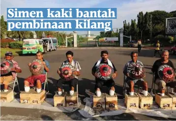 ??  ?? KUMPULAN petani dengan kaki bersimen duduk di hadapan Istana Presiden di Jakarta kelmarin bagi membantah kelulusan kilang simen di kampung mereka. - Kompas.com