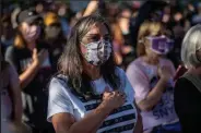  ?? Sergio Flores / Getty Images ?? Protesters listen to the National Anthem on Saturday as they take part in the Women's March and Rally for Abortion Justice in Austin, Texas.