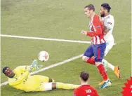  ??  ?? Antoine Griezmann supera al portero Mandanda con un tiro suave para marcar el segundo gol del Atletico.