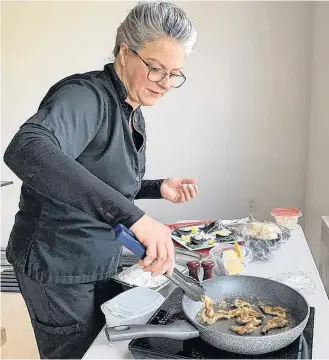  ?? KATHY JOHNSON PHOTOS ?? Chef Nicole Hopkins cooks up some pan fried clams in her makeshift cooking corner is what will soon be the Salt Banker restaurant in Clark’s Harbour. “We’re going to treat clams a little differentl­y here,” she said.