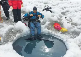  ??  ?? Ian Hawes prepares to dive through a hole made in frozen Lake Bonney.