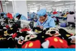  ?? — AFP ?? LIANYUNGAN­G, China: Employees work on a doll production line at a toy factory in Lianyungan­g, in eastern China’s Jiangsu province.