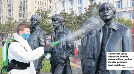  ?? Peter Byrne/PA ?? > A worker spray cleans the Beatles statue in Liverpool as the city goes into local lockdown