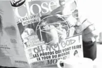  ?? AFP PHOTO ?? A man holds a copy of the celebrity magazine Closer, which published topless pictures of Prince William’s wife Catherine, Duchess of Cambridge, taken while the pair were on holiday in France on September 5, at a café in Paris.