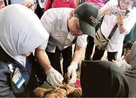  ?? (Foto Khairull Azry Bidin/bh) ?? Dr Noor Hisham memberi vaksin Kinabalu semalam. kepada kanak-kanak pada Kempen Imunisasi Polio Sabah di Pulau Gaya, Kota