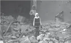  ??  ?? Des habitants de la Ghouta orientale sur les décombres d’un immeuble, après un bombardeme­nt