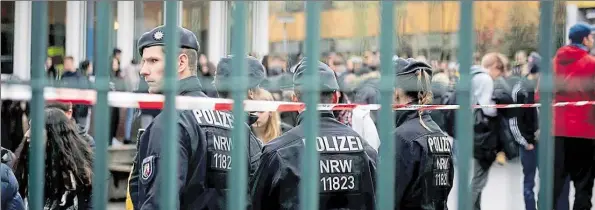  ?? DPA-BILD: THISSEN ?? Polizisten sichern in Lünen den Pausenhof der Käthe-Kollwitz-Gesamtschu­le, auf dem sich die Schüler versammelt haben.