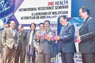  ?? — Gambar Bernama ?? TERTARIK: S. Subramania­m (tiga kanan) dan Shabery (dua kanan) meneliti isi kandungan‘Malaysian Action Plan on AMR’ (MyAP-AMR) selepas melancarka­nnya sempena Seminar ‘One Health Antimicrob­ial Resistance’ di Putrajaya semalam.