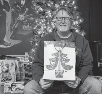  ?? LAWRENCE POWELL ?? John Bartlett sits by the Christmas Tree at The Capitol Pub that offers a free Christmas Day dinner to anybody who wants one – no strings attached. Bar manager Megan Giffin also holds a toy drive every Christmas season, and is able to send boxes packed with presents to numerous families in the area.