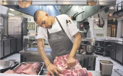  ?? Pictures: AFP ?? SPICE OF LIFE. Germaine Esau, chef de cuisine at the Myoga fine-dining restaurant, prepares a side of beef for smoking. He often uses Baleni salt in his culinary creations in Cape Town. The Baleni salt is sacred to locals in the remote northern region of South Africa where it is mined from a spring.