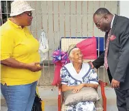  ??  ?? Pastor Carl Brooks and head deaconess Jasmine Simms of the Washington Gardens SDA Church congratula­te the eldest pensioner, Nurse Chance, 95, on being awarded a rocking chair at Western District Post Office pensioners’ treat hosted by the church recently.