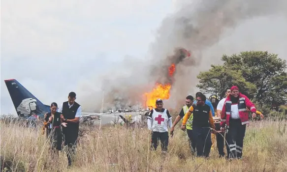  ?? Picture: AP ?? Red Cross and other rescue workers help injured people from an Aeromexico airliner which crashed near Durango, Mexico, on Tuesday.