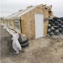  ??  ?? Recycled beer cans and tires were used to build an urban earthship greenhouse at the Grow Calgary garden on the western edge of the city.