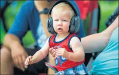  ?? KYLE TELECHAN/POST-TRIBUNE ?? Braden Yonkman, 1, watches emergency vehicles roll by with his parents during the Griffith Fourth of July parade on Saturday.