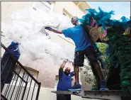  ?? ?? Henry Spillman (from right), Smith and Dorien Bryant with Bayou Services Moving load Mardi Gras costume pieces Oct. 12 from the Central School Arts and Humanities Center.