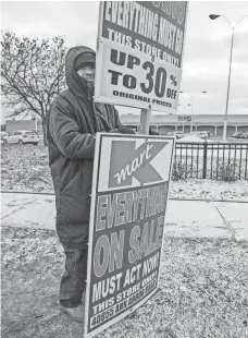  ?? BILL BRESLER, USA TODAY NETWORK ?? Braving 16-degree temperatur­es, Milton Murray holds a sign advertisin­g clearance sales at the Ann Arbor Road Kmart in Plymouth Township, Pa.