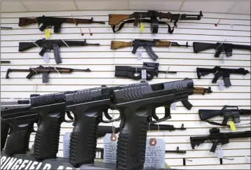  ?? SETH PERLMAN — THE ASSOCIATED PRESS FILE ?? Assault weapons and hand guns are seen for sale at Capitol City Arms Supply in Springfiel­d, Ill., on Jan. 16, 2013. Visa is pausing a decision to start categorizi­ng purchases at gun shops.