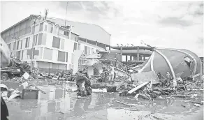  ?? RIFKI RIFKI/AP ?? People survey the damage Sunday following a massive earthquake and tsunami in Palu, Central Sulawesi, Indonesia.