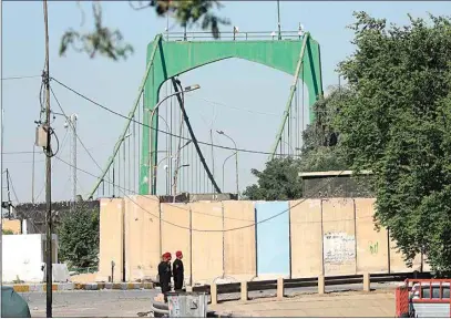  ?? HADI MIZBAN / AP ?? Iraqi security forces close the heavily fortified Green Zone on Sunday as they tighten security measures hours after an assassinat­ion attempt on Prime Minister Mustafa al-Kadhimi, in Baghdad, Iraq. Al-Kadhimi survived the attack by armed drones that targeted his residence and officials said he escaped unharmed.