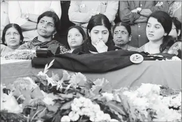  ?? Aijaz Rahi
Associated Press ?? K.G. RADHIKA, center, looks at the coffin of husband Niranjan Kumar in Bangalore, India. The commando was killed in the attack on the Pathankot base, which began Saturday. Six other soldiers also were killed.