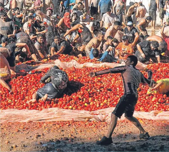  ?? Picture: AP. ?? People throw tomatoes at each other during the Summer Fest in Quillon, around 300 miles south of Santiago in Chile. More than 100 tons of tomatoes are used during the three-hour battle.