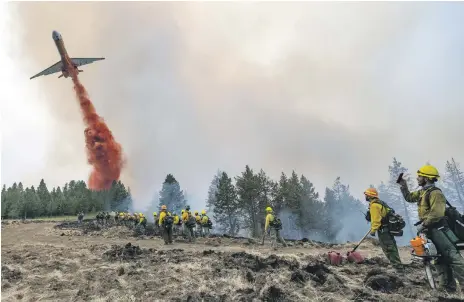  ?? AP ?? A plane drops fire retardant on Harlow Ridge above the Lick Creek Fire, south-west of Asotin in Washington state, on Monday