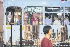  ??  ?? A tram is seen decorated with Britain’s Houses of Parliament as commuters travel during the evening in Hong Kong. Hong Kong’s latest attempt at cooling home prices in one of the world’s most expensive property markets is expected to send buyers...