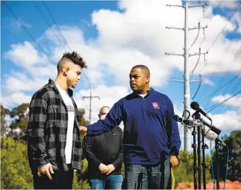  ?? SAM HODGSON ?? Scripps Ranch coach Marlon Gardinera and his son Nicholas, one of two plaintiffs in the lawsuit, speak at a news conference at Torrey Highlands Park on Thursday. A settlement will allow youth sports to resume.
U-T