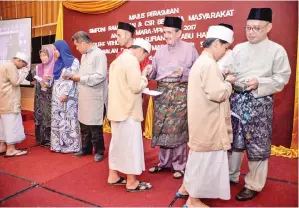  ??  ?? JUHARI, Sufian, Basrih dan para pegawai Mara menyampaik­an sumbangan kepada anak yatim.