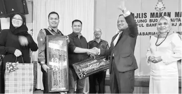  ??  ?? Saiful, with his wife Sabariah Ibrahim on his left, waves to the crowd as he receives his birthday gifts. At fourth left is Sibu deputy police chief Supt Martin Koo.