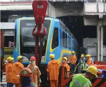  ??  ?? WORKERS install one of the newly acquired Metro Rail Transit 3 (MRT-3) coach at the Taft Station at the corner of Taft Avenue and EDSA in Pasay City.