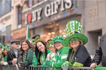  ?? ANGELA WEISS/AFP VIA GETTY IMAGES ?? Spectators look on during the St. Patrick’s Day parade in New York City on Friday.