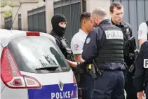  ??  ?? French police officers talk as two people have been detained after a possible explosives laboratory was discovered in Villejuif on Wednesday. (AP)