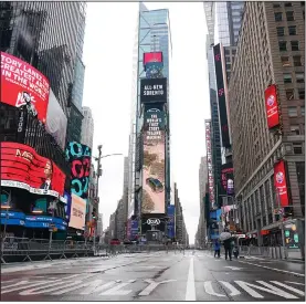  ?? (AP/Frank Franklin II) ?? People walk in a nearly empty Times Square ahead of the New Year’s Eve celebratio­n Thursday night in New York.