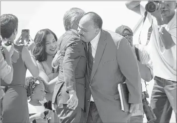  ?? CAROLYN KASTER/ASSOCIATED PRESS ?? Martin Luther King III (right) hugs Al Sharpton after speaking at Saturday’s event. In the background at left are his wife Arndrea King and daughter Yolanda.