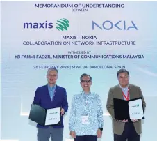  ?? ?? Fahmi (centre) witness the MoU exchange between Nokia and Maxis represente­d by Ngiam (left) and Goh.