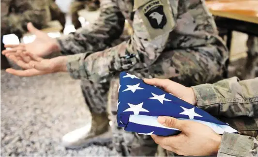  ?? BILD: SN/AFP/WAKIL KOHSAR ?? Ein US-Soldat in Afghanista­n, in den Händen die Flagge Stars and Stripes.