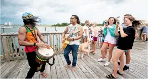  ?? EFE ?? Una banda musical improvisó una fiesta con personas que paseaban junto al muelle en Wilmington, Carolina del Norte, desafiando la orden de evacuación/