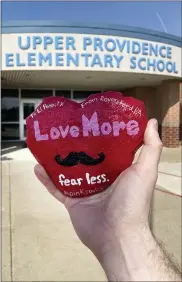  ?? BRIAN AIKENS VIA AP ?? In this March 2021 photo provided by teacher Brian Aikens, Aikens holds up a heart-shaped “kindness rock” memorializ­ing Texas teacher Zelene Blancas, who died of COVID-19 in December 2020, outside Upper Providence Elementary School in Royersford. The stone was decorated and transporte­d across the country by a handful of people to El Paso’s Dr. Sue A. Shook Elementary School, where Blancas taught and was remembered by her principal as someone who “embodied kindness.”